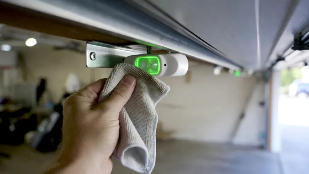 cleaning garage door safety sensor lens to fix blinking green light